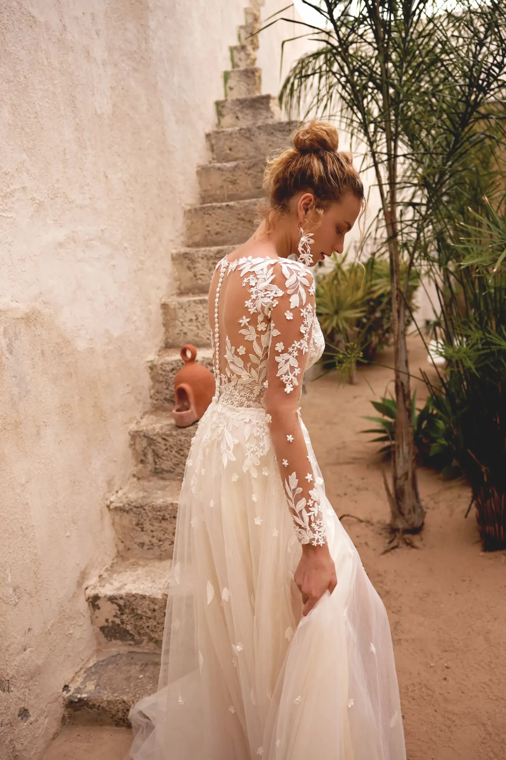 Model is wearing a tulle long sleeve wedding dress by lillian west