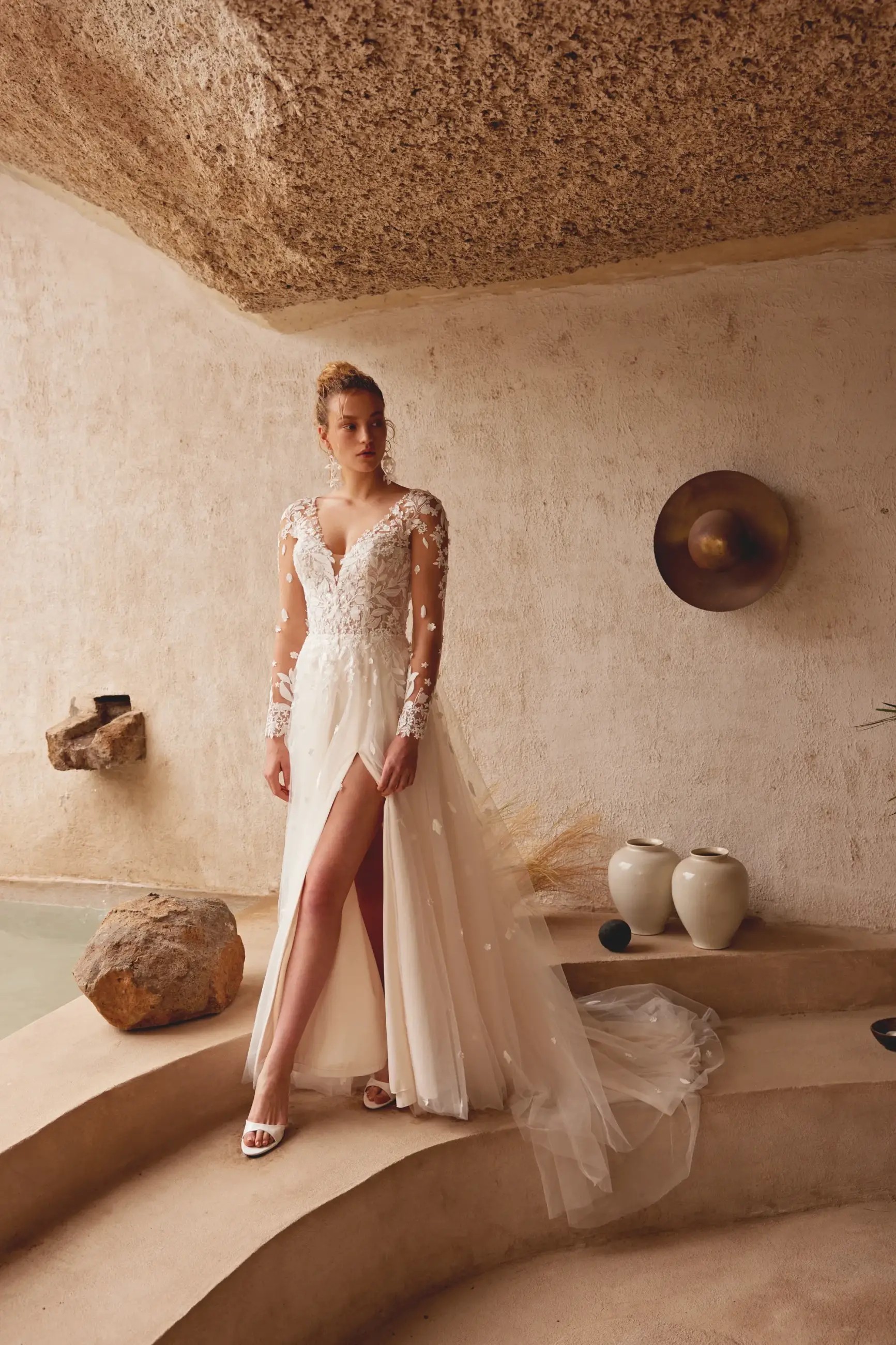 Model is wearing a tulle long sleeve wedding dress by lillian west