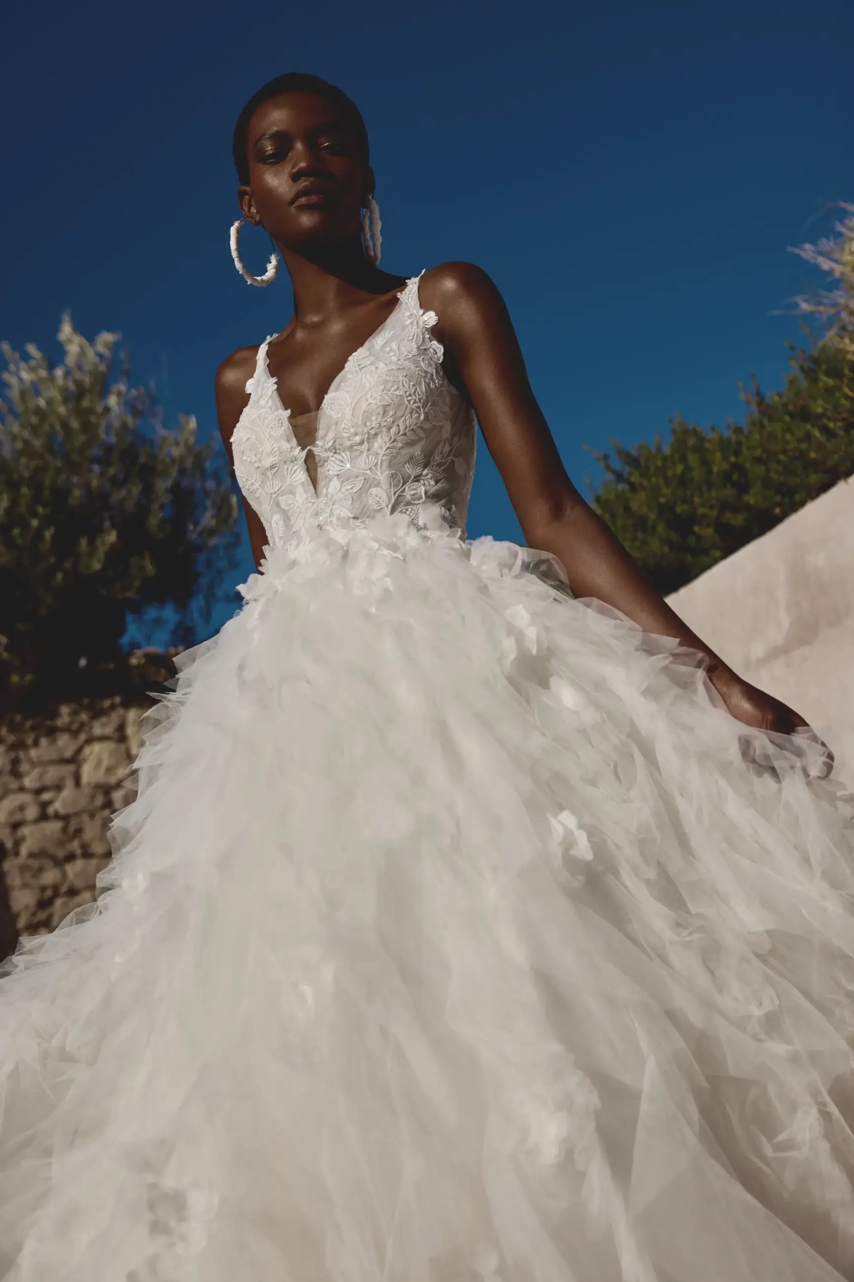 Model is wearing a shimmery tulle wedding dress by lillian west