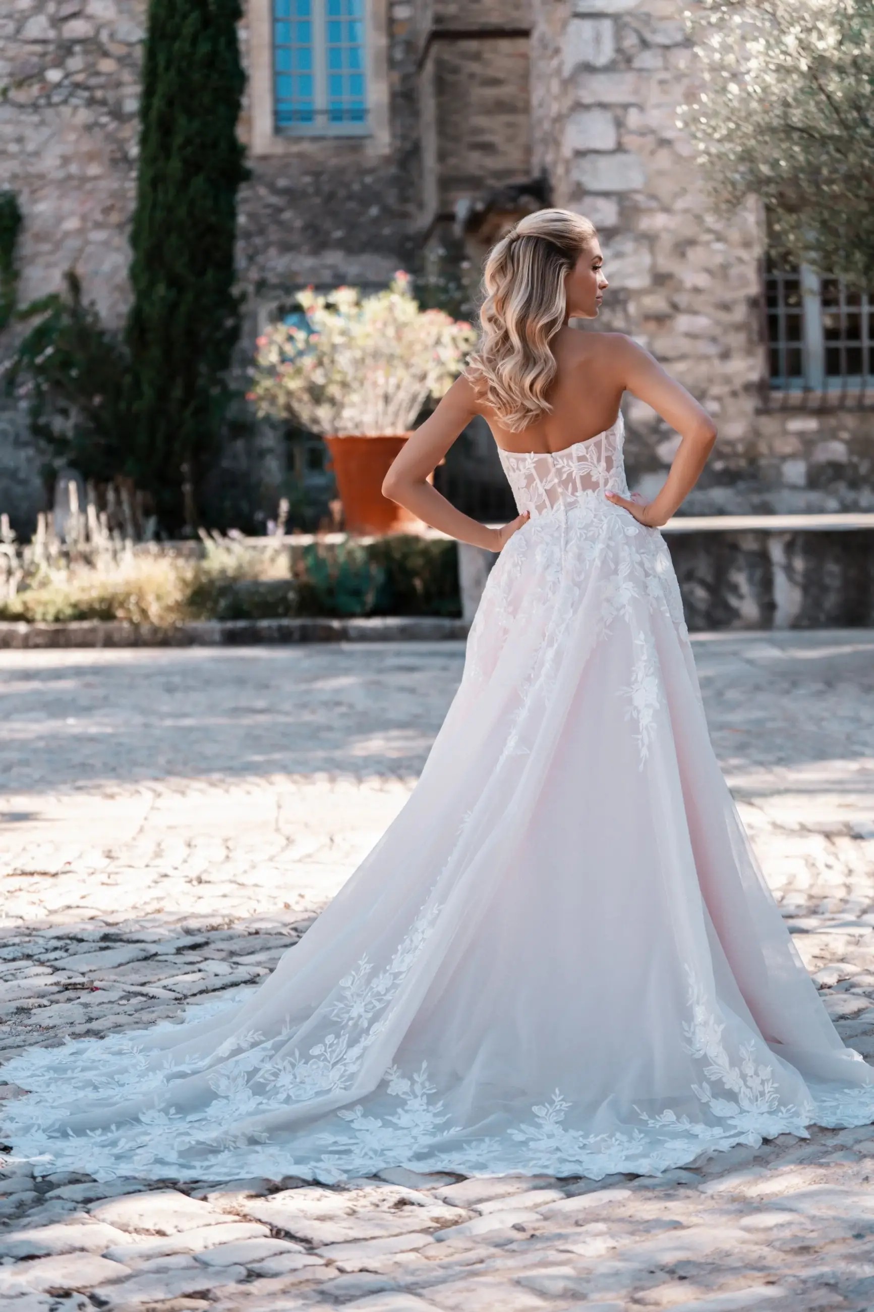 Model is wearing a beaded floral lace strapless wedding dress by allure bridals