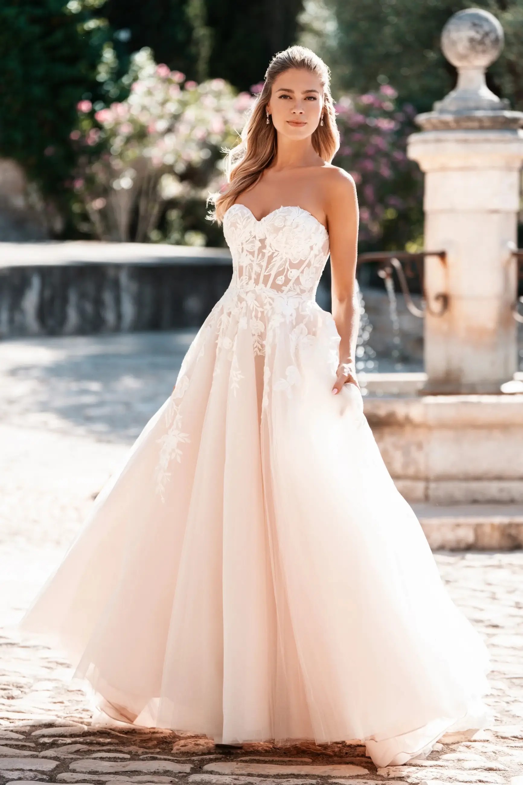 Model is wearing a beaded floral lace strapless wedding dress by allure bridals